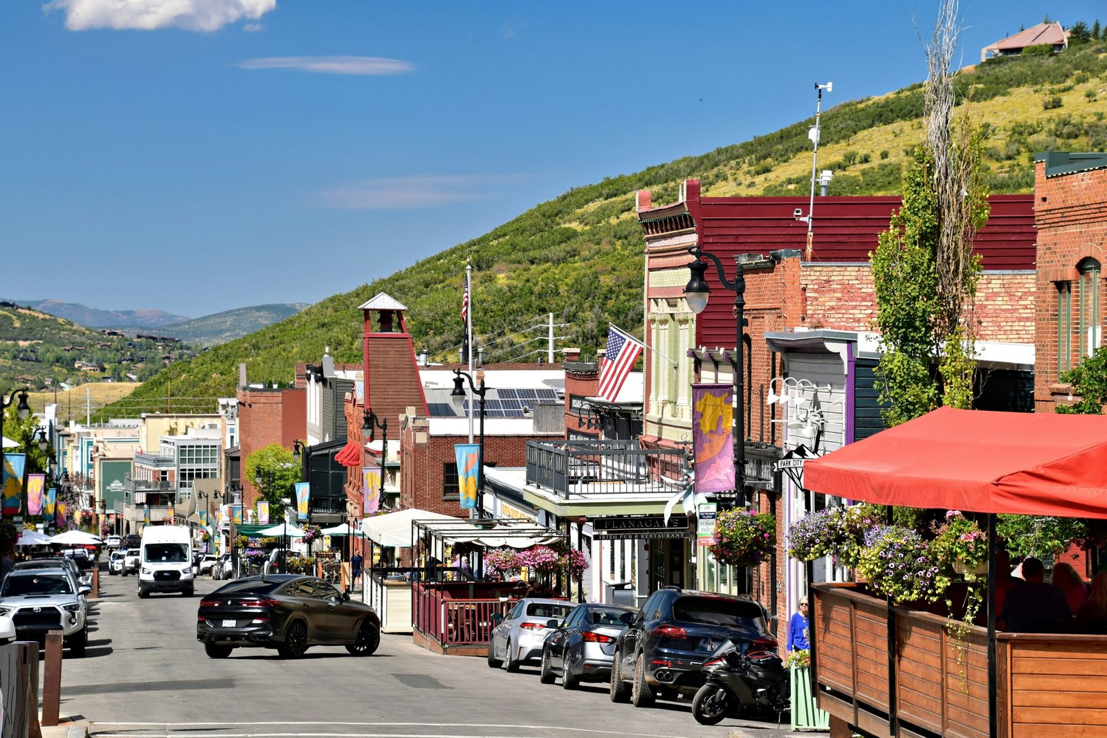 Luxury Park City Utah mountain home in summer with green landscaping and clear blue sky, ideal for a seasonal vacation rental strategy.